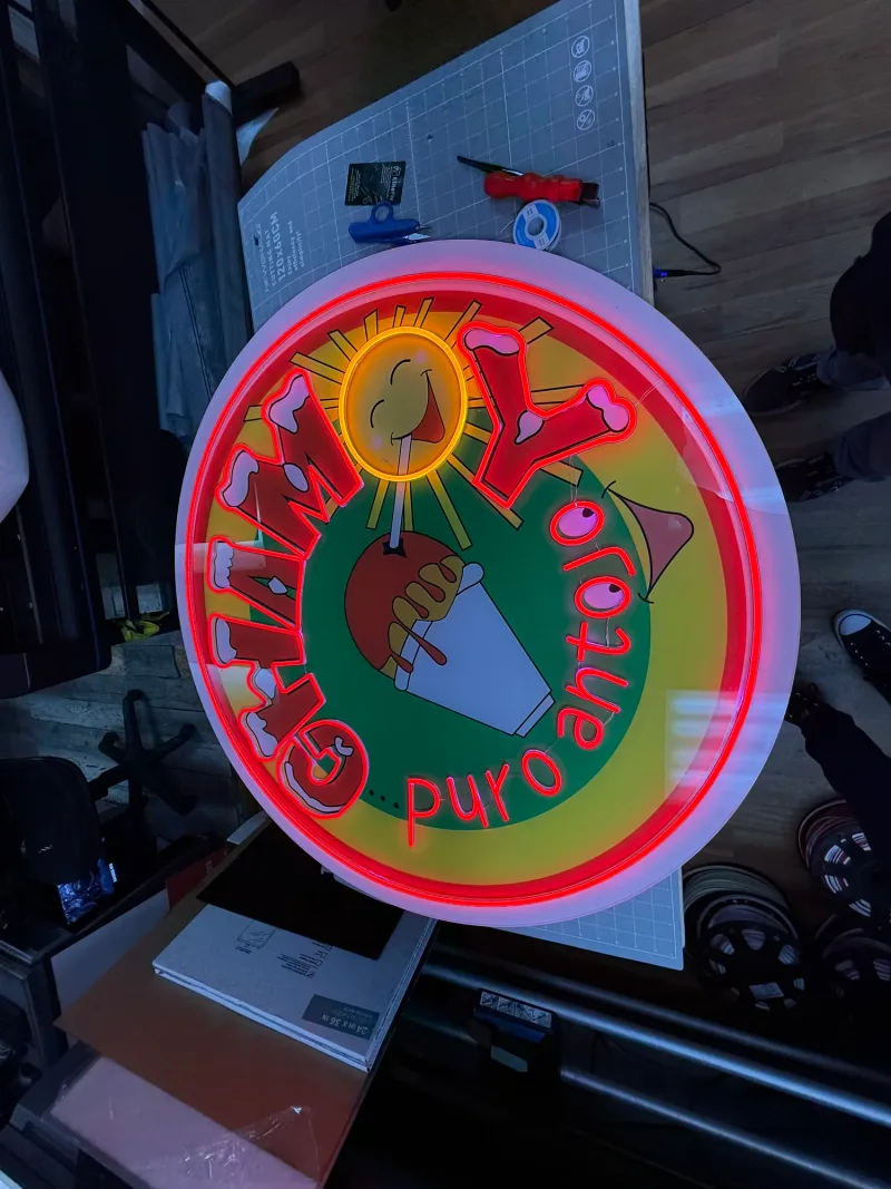 The Chamoy LED neon sign finished on the shop cutting table next to the plotter